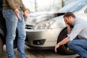 Two men arguing after a car accident on the road