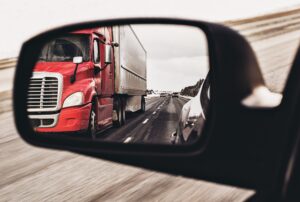 Semi Truck in Side View Mirror of a Car